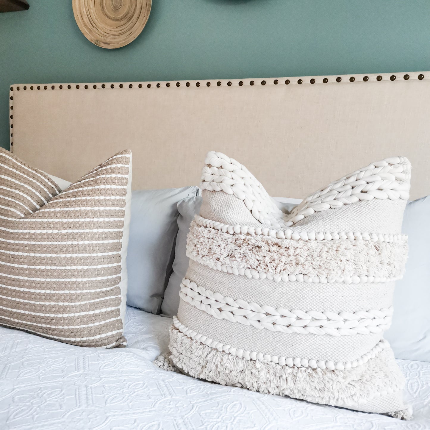 Bed with white frill cushion and beige pillow