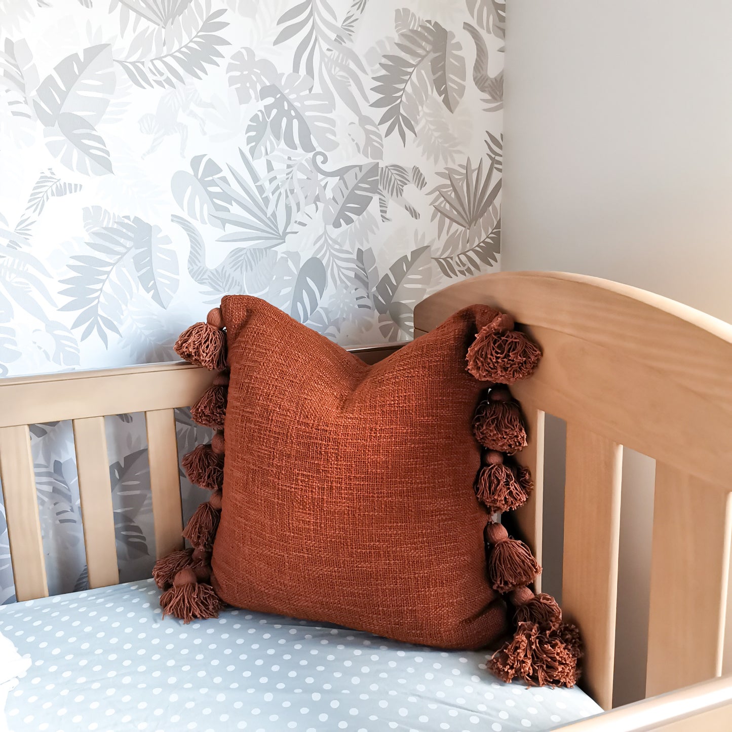 Nursery room cushion with tassels