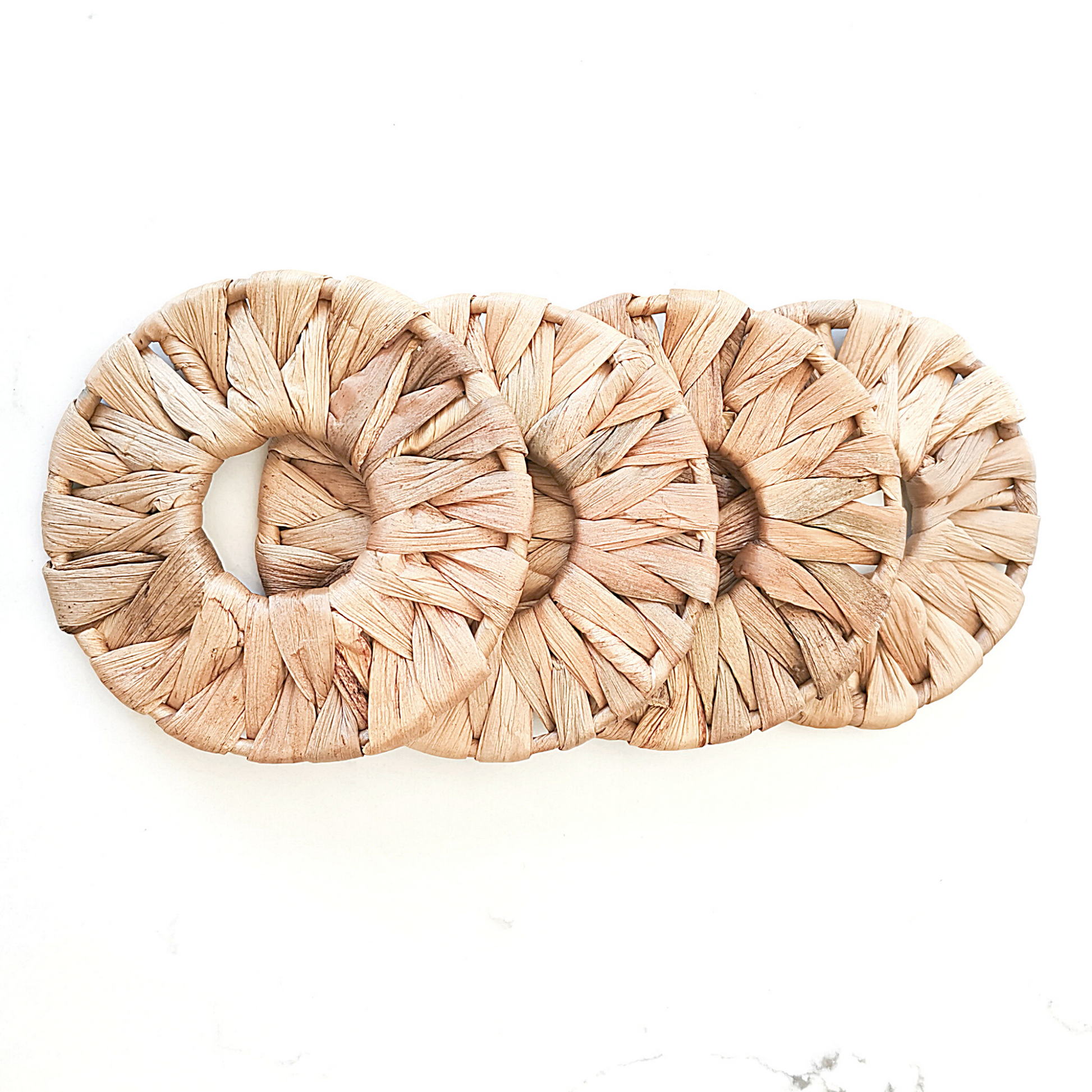 Rounded natural seagrass coasters for protecting table surfaces.