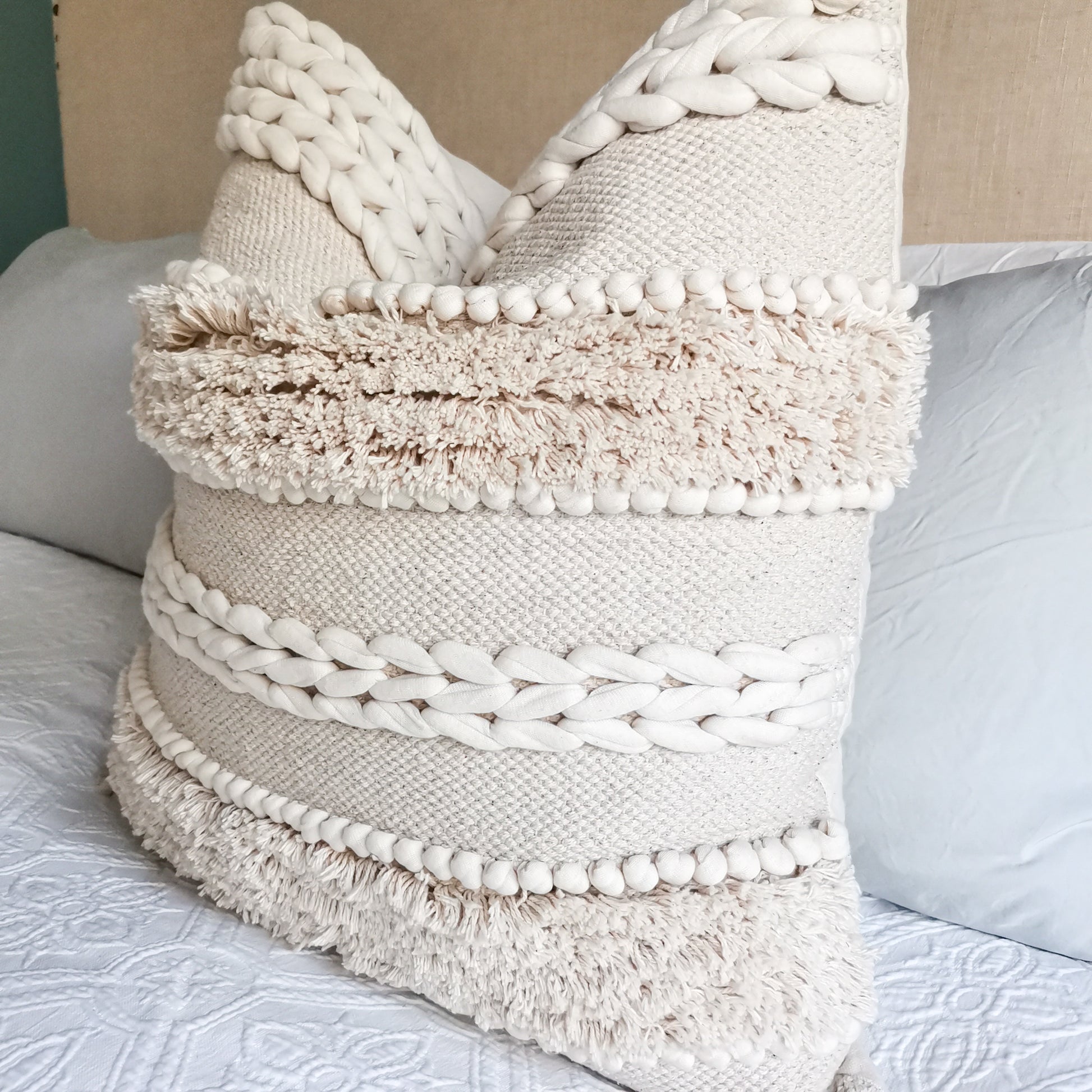 ivory white cushion on a bed